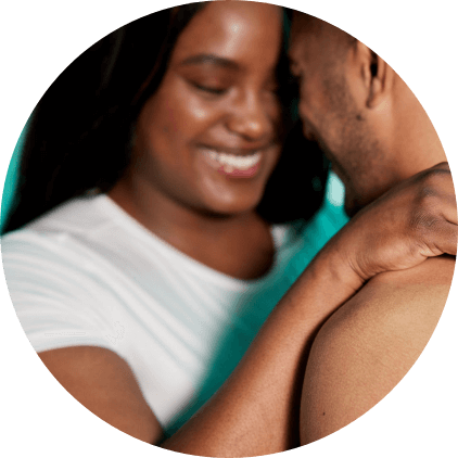 A woman smiling with her arms around a man.