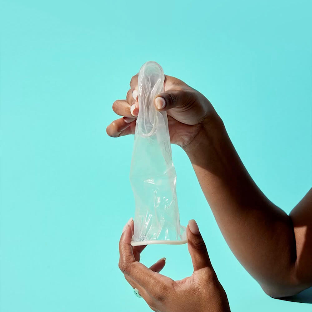 Video preview. Image of woman pinching inner ring of FC2 condom.