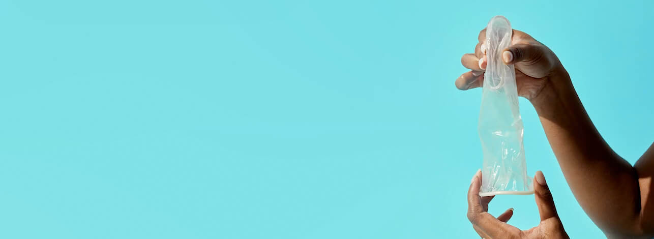 Video preview. Image of woman pinching inner ring of FC2 condom.